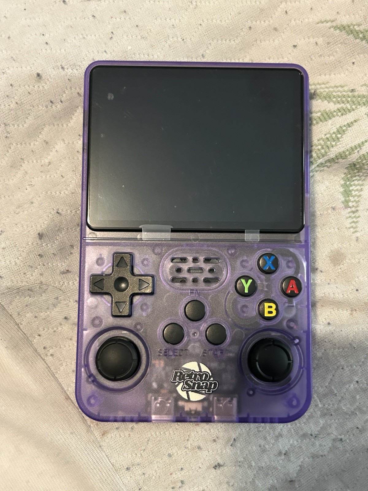 R36S retro handheld game console in transparent purple Aka “Retro Snap”