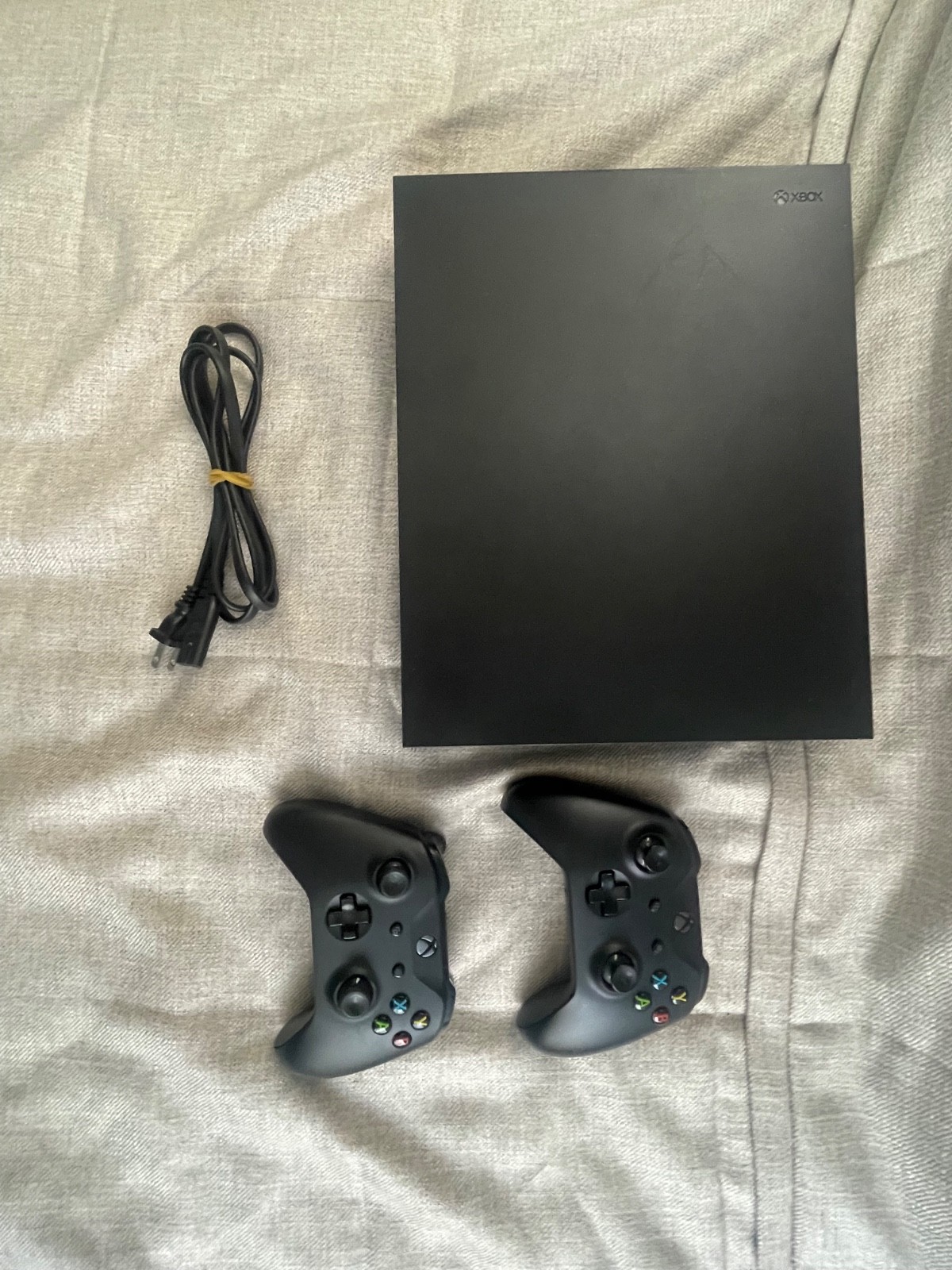 Black Microsoft Xbox One X 1TB Home Console. 2 controllers, console, power cord.