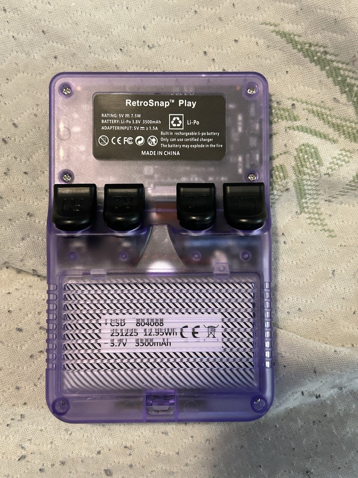 R36S retro handheld game console in transparent purple Aka “Retro Snap”