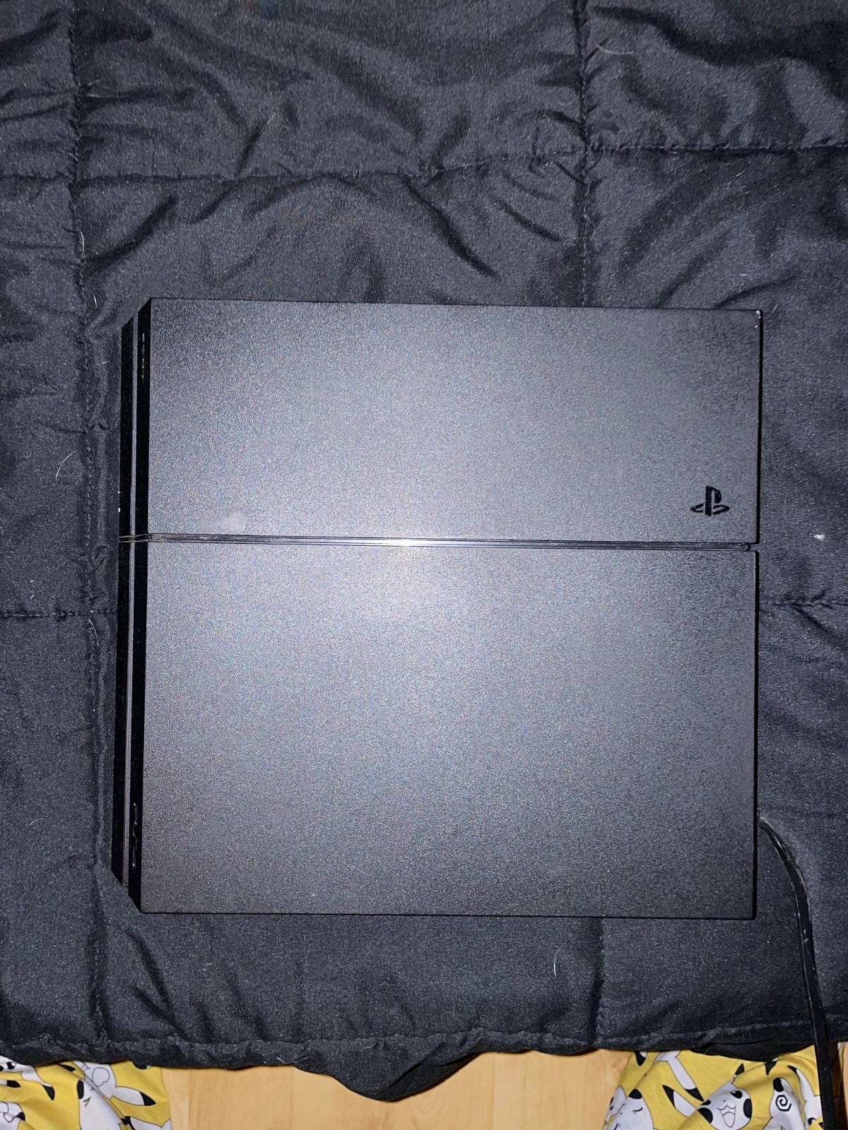 ps4 console with cords, 3 controllers, and wall mount